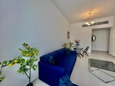 a living room with a blue couch and a table at Al Karama close to subway in Dubai