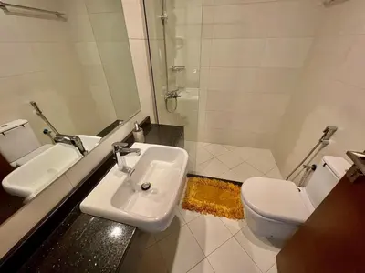 a bathroom with a white sink and a toilet at Al Karama close to subway in Dubai
