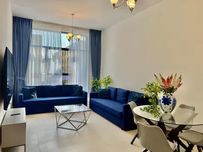 a living room with a blue couch and a table at Al Karama close to subway in Dubai