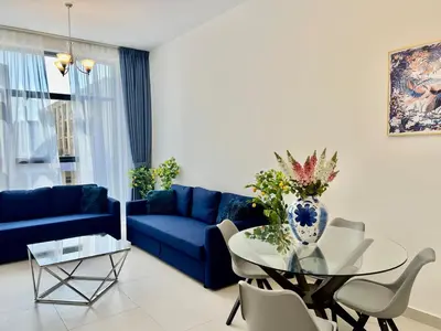 a living room with a blue couch and a glass table at Al Karama close to subway in Dubai