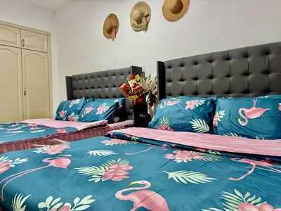 a bedroom with two beds with pink flamingos on them at Mina Road AL Thayer in Dubai