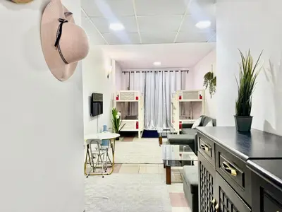 a living room with white walls and a black counter top at Mina Road AL Thayer in Dubai