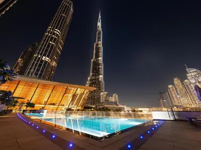 a pool in the middle of a city at night at Downtown Luxury - 4 Minutes Walk to Dubai Mall & Burj Khalifa in Dubai