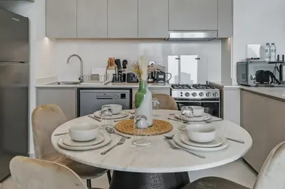 a kitchen with a white table with chairs and a tableablish at Downtown Luxury - 4 Minutes Walk to Dubai Mall & Burj Khalifa in Dubai