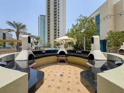 a courtyard with a pool and an umbrella at Classy Studio in the Heart of Greens in Dubai