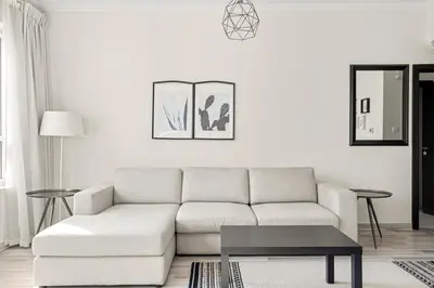 a white living room with a white couch and a table at Elegant 1-Bedroom Apartment in Dubai Marina in Dubai
