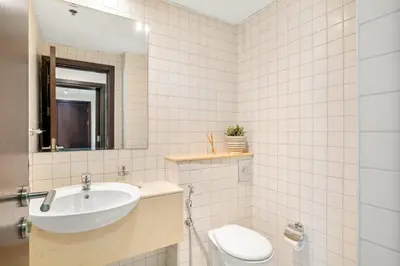 a bathroom with a sink and a toilet and a mirror at Elegant 1-Bedroom Apartment in Dubai Marina in Dubai