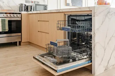 a dishwasher with dishes in it in a kitchen at Central Park Building, City Walk - 1BR Sophisticated Apartment in Dubai