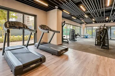 a gym with treadmill and ellipticals in a room with windows at Central Park Building, City Walk - 1BR Sophisticated Apartment in Dubai