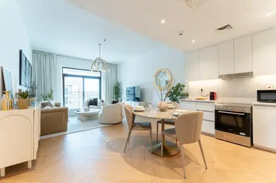 a kitchen and living room with a table and chairs at Modern 1BR Steps from Burj AlArab Madinat Jumeirah By AYA Boutique in Dubai