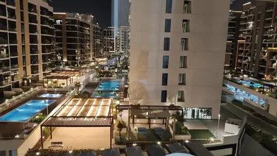 a view of a building with a swimming pool at Charming Studio with Pool, Gym, Kid's playground in Dubai