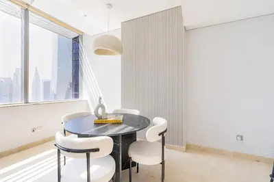 a dining room with a black table and white chairs at Chic Urban Loft SkyGardens DIFC, Dubai in Dubai