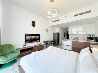 a living room with a large bed and a kitchen at Modern Studio with Stunning City Views in Dubai