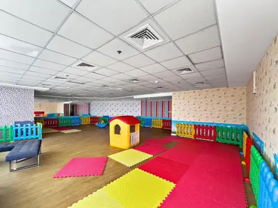 a large room with a playroom with colorful mats and a play room with at Spacious Studio - 10 min drive to Burj Khalifa in Dubai