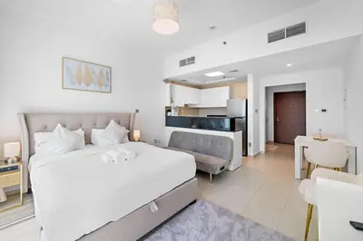 a bedroom with a bed and a living room at Spacious Studio - 10 min drive to Burj Khalifa in Dubai