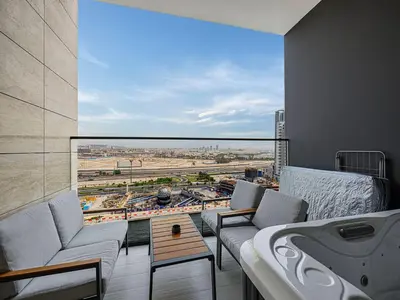 a balcony with a couch and a view of a city at Daniels Studio with Private Jacuzzi & Canal View in Dubai