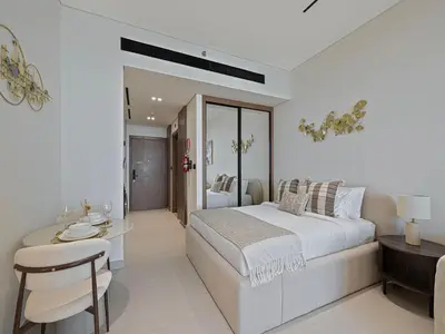 a white bedroom with a large bed and a table at Daniels Studio with Private Jacuzzi & Canal View in Dubai