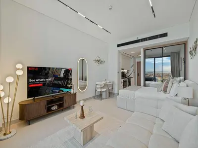 a living room with a white couch and a tv at Daniels Studio with Private Jacuzzi & Canal View in Dubai