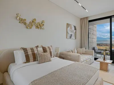 a white bedroom with a bed and a couch at Daniels Studio with Private Jacuzzi & Canal View in Dubai