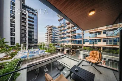 an apartment balcony with a table and chairs at Kensington Waters, MBR City, Dubai in Dubai