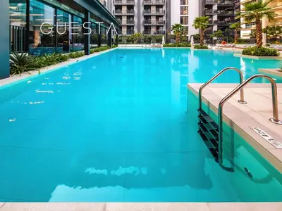 a large pool with blue water in a building at Kensington Waters, MBR City, Dubai in Dubai