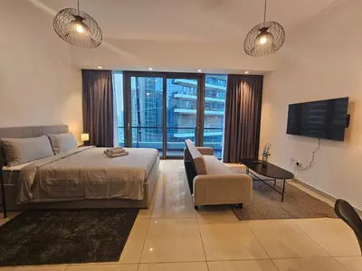 a bedroom with a bed and a tv and a couch at Dubai Silverene Tower with large balcony and high floor Marina views in Dubai