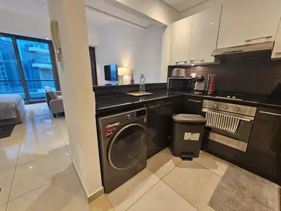 a kitchen with a washing machine and a sink at Dubai Silverene Tower with large balcony and high floor Marina views in Dubai
