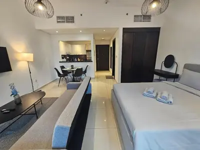 a bedroom with a large bed and a dining room at Dubai Silverene Tower with large balcony and high floor Marina views in Dubai