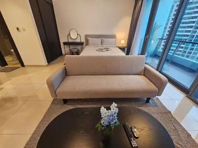 a living room with a bed and a couch at Dubai Silverene Tower with large balcony and high floor Marina views in Dubai