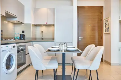 a kitchen with a table with chairs and a washer at STAY BY LATINEM Luxury 1BR Holiday Home CVR A1814 near Burj Khalifa in Dubai