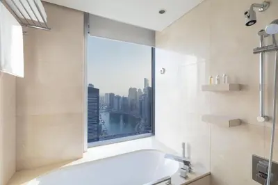 a bathroom with a bath tub and a window at Amazing Dubai Marina Studio Pool Beach Sea View in Dubai