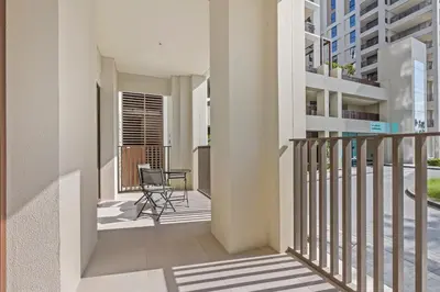 a balcony with a chair and a table in a building at Spacious 1 bedroom in creek beach-Huge Balcony in Dubai