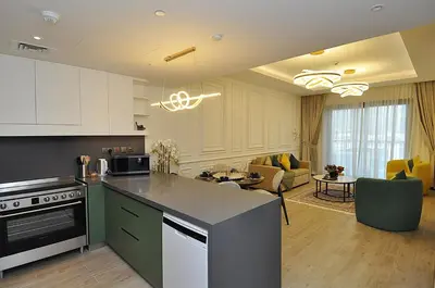 a kitchen with a counter top and a living room at Luxury 1 Bedroom Burj Khalifa View Citywalk in Dubai