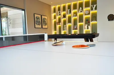 a ping pong table in a room with a yellow wall at Luxury 1 Bedroom Burj Khalifa View Citywalk in Dubai
