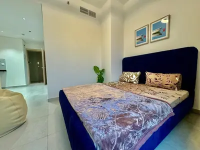a bedroom with a bed with a blue head board at Spacious unit with a terrace in Dubai