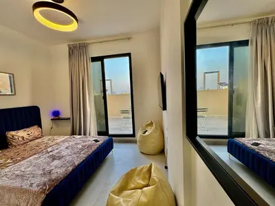 a bedroom with a bed and a window with a view at Spacious unit with a terrace in Dubai