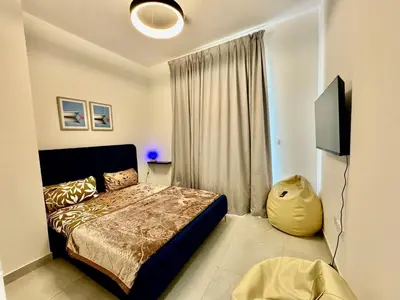 a bedroom with a bed and a flat screen tv at Spacious unit with a terrace in Dubai