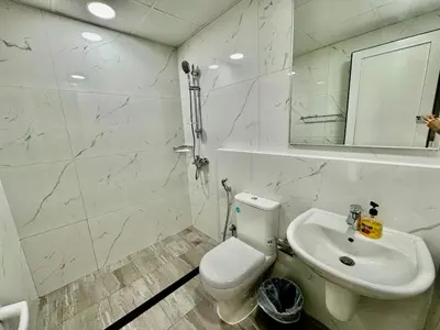 a white bathroom with a toilet and a sink at Spacious unit with a terrace in Dubai