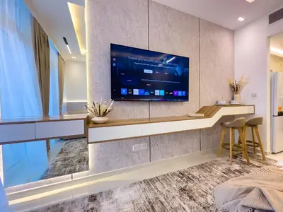 a living room with a large television on a wall at Damac Carson B Studio, Scenic & Serene Stay in Dubai