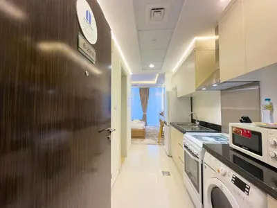 a kitchen with a door with a microwave and a stove at Damac Carson B Studio, Scenic & Serene Stay in Dubai