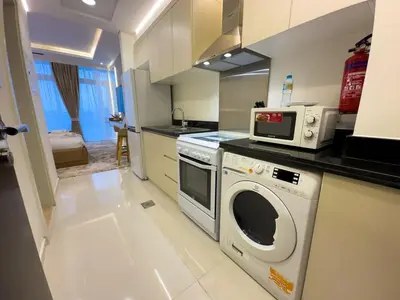 a kitchen with a washing machine and a microwave at Damac Carson B Studio, Scenic & Serene Stay in Dubai