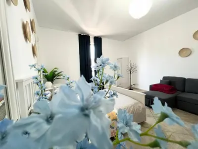 a living room with a couch and blue flowers at Motor City Shakespeare Circus in Dubai