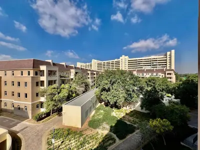 an overhead view of a large white building with trees at Motor City Shakespeare Circus in Dubai