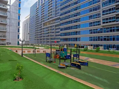 a park with a playground in front of a large building at Modern Studio in Skycourts, Near Dubai Outlet Mall in Dubai