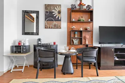 a dining room with a table and chairs and a television at Modern Studio in Skycourts, Near Dubai Outlet Mall in Dubai