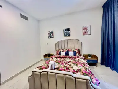 a bedroom with a large bed with flowers on it at Jaddaf Pool Gym Parking in Dubai