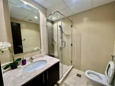 a bathroom with a sink and a shower and a toilet at Jaddaf Pool Gym Parking in Dubai