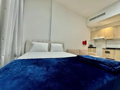 a bedroom with a large bed with a blue blanket on it at Sleep 3 Walk to ADCB metro in Dubai