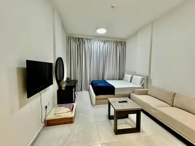 a room with a couch and a bed and a tv at Sleep 3 Walk to ADCB metro in Dubai