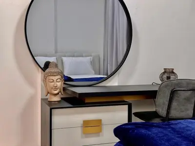 a room with a mirror on a table with a bust at Sleep 3 Walk to ADCB metro in Dubai